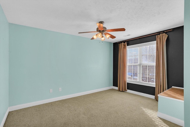 spare room with light colored carpet, a textured ceiling, and ceiling fan