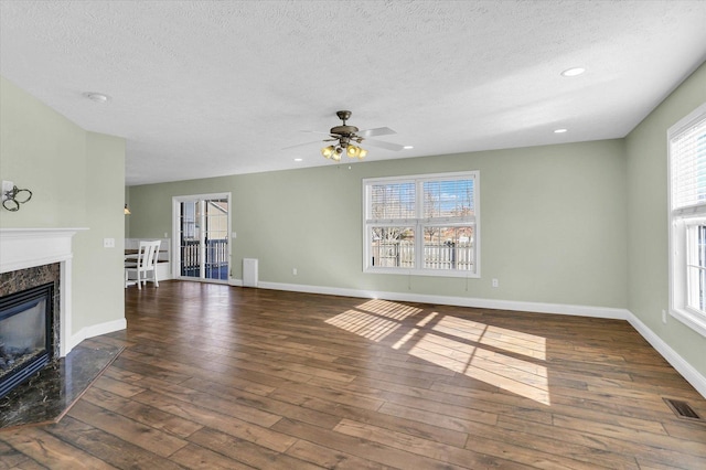 unfurnished living room with a premium fireplace, a textured ceiling, and dark hardwood / wood-style flooring