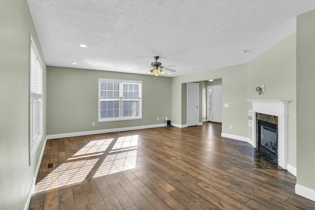 unfurnished living room featuring dark hardwood / wood-style flooring, a premium fireplace, and a textured ceiling