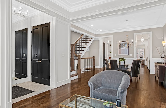 foyer with crown molding, a notable chandelier, and dark hardwood / wood-style flooring