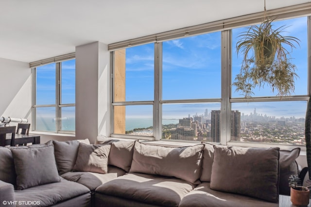 living room with a wall of windows, a healthy amount of sunlight, and a water view