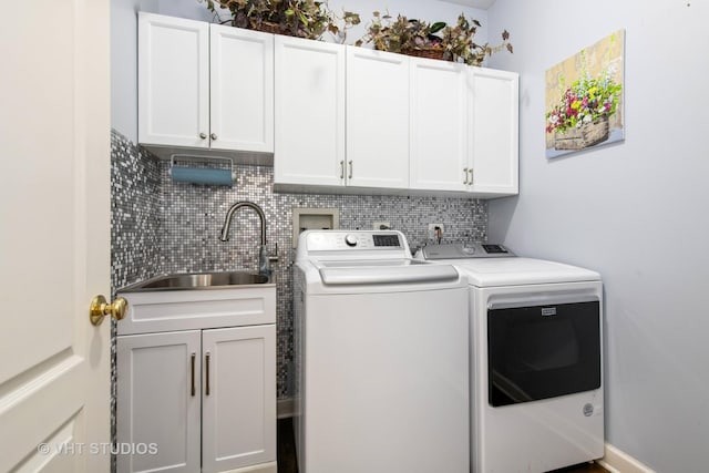 laundry area featuring washing machine and dryer, sink, and cabinets