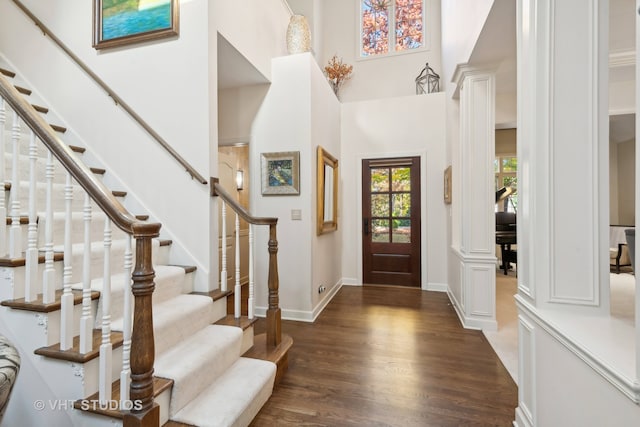 entryway featuring dark hardwood / wood-style flooring and a towering ceiling