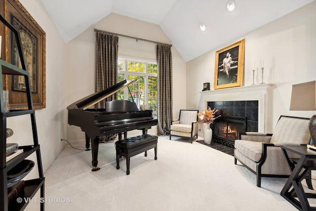 sitting room with carpet flooring, a tiled fireplace, and lofted ceiling