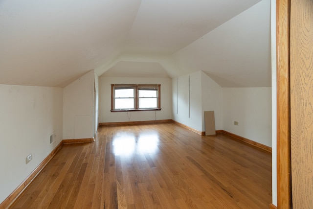 bonus room featuring lofted ceiling and light hardwood / wood-style floors