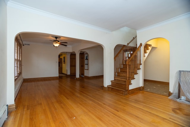 unfurnished living room with crown molding, a baseboard heating unit, hardwood / wood-style flooring, and ceiling fan