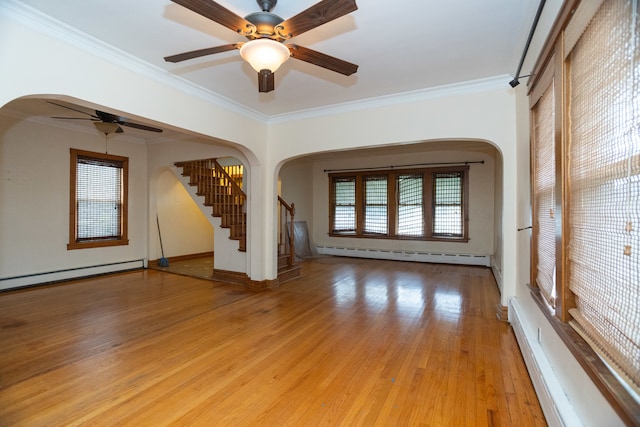 spare room featuring ornamental molding, light wood-type flooring, and a wealth of natural light