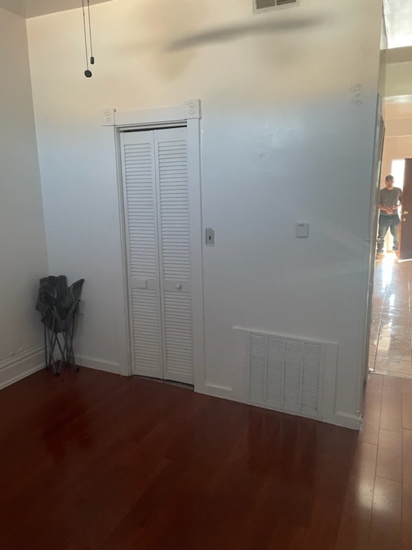 unfurnished bedroom featuring dark wood-type flooring and a closet