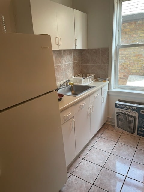 kitchen with white cabinets, a healthy amount of sunlight, and white fridge