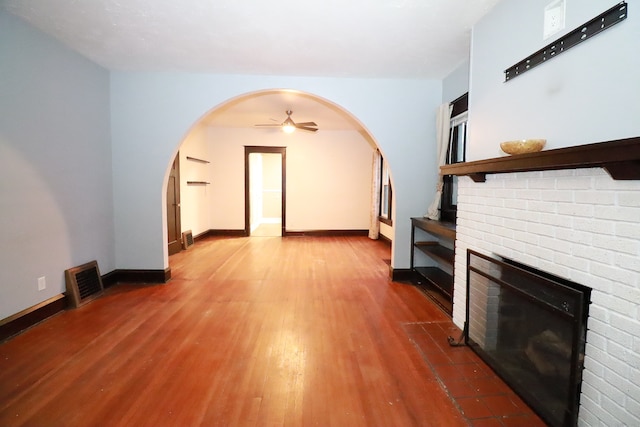 unfurnished living room featuring ceiling fan, a fireplace, and hardwood / wood-style flooring