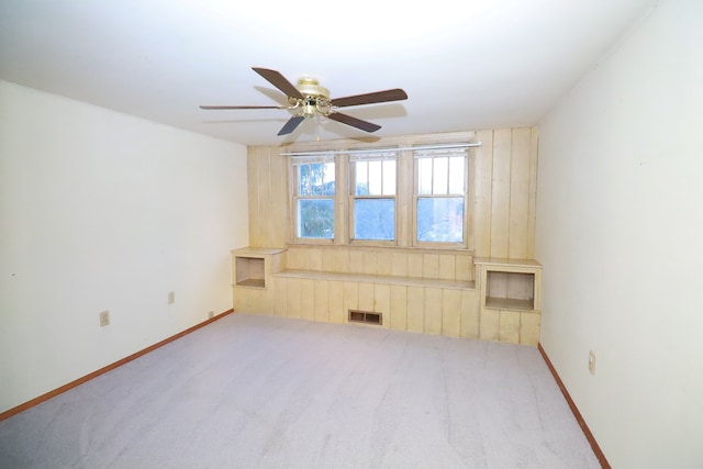 carpeted empty room featuring ceiling fan