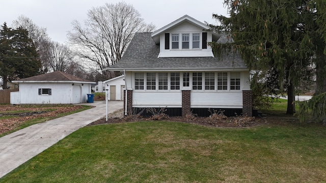 view of front of property featuring an outbuilding, a front lawn, and a garage