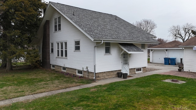 exterior space featuring an outbuilding, a front yard, and a garage