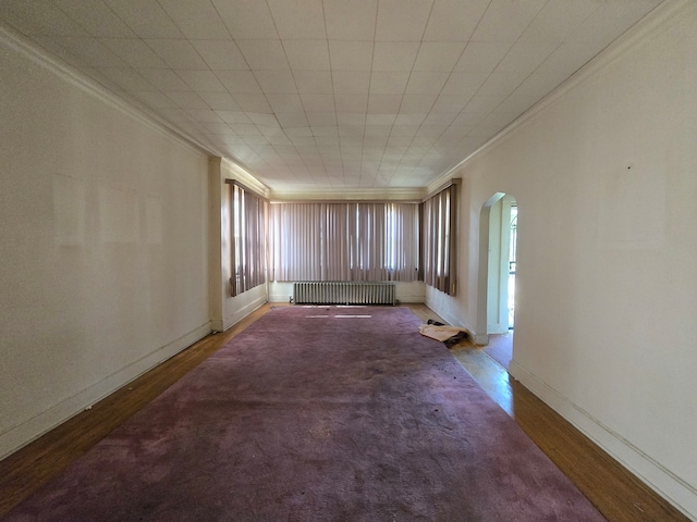 spare room with ornamental molding, radiator heating unit, and hardwood / wood-style flooring