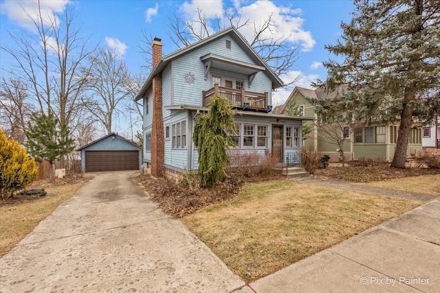 view of front of home featuring an outbuilding, a garage, a front yard, and a balcony