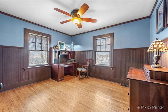 office with crown molding, ceiling fan, wooden walls, and light hardwood / wood-style flooring