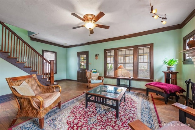 living room with crown molding, ceiling fan, and light hardwood / wood-style flooring