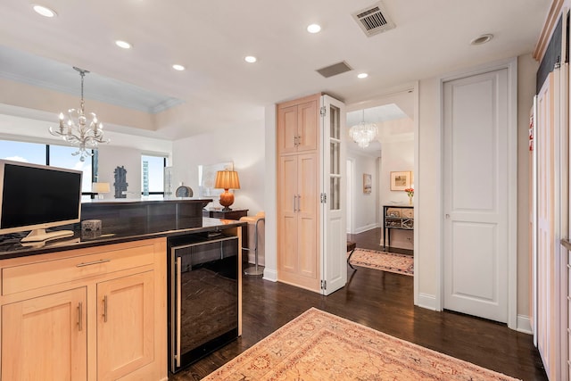 kitchen featuring dark hardwood / wood-style floors, light brown cabinetry, decorative light fixtures, wine cooler, and ornamental molding