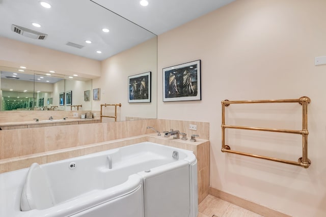 bathroom with a washtub and tile patterned floors