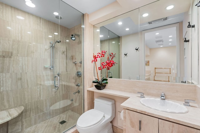 bathroom featuring vanity, toilet, and a shower with door