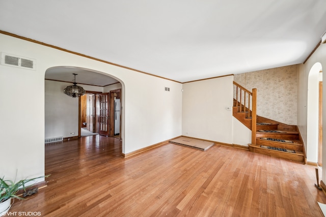 interior space with hardwood / wood-style floors, crown molding, and an inviting chandelier