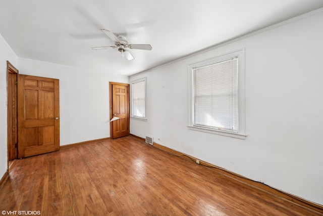 unfurnished bedroom with ornamental molding, hardwood / wood-style floors, and ceiling fan