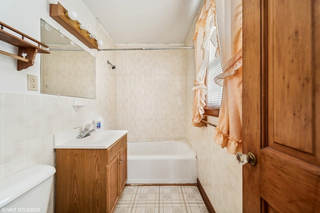 full bathroom featuring toilet, vanity, tile walls, and shower / bath combination