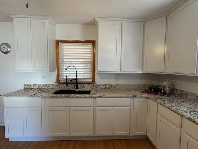 kitchen featuring white cabinetry, sink, and hardwood / wood-style flooring