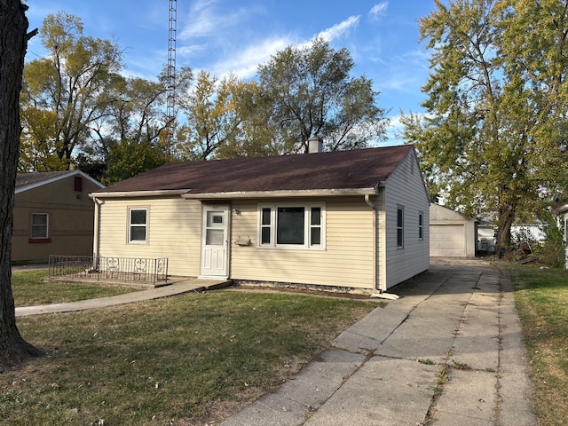 view of front facade featuring a front yard, an outdoor structure, and a garage