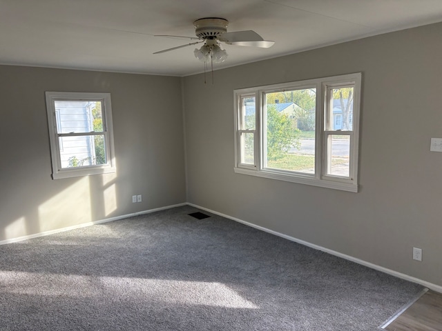 spare room with ceiling fan, carpet floors, and plenty of natural light