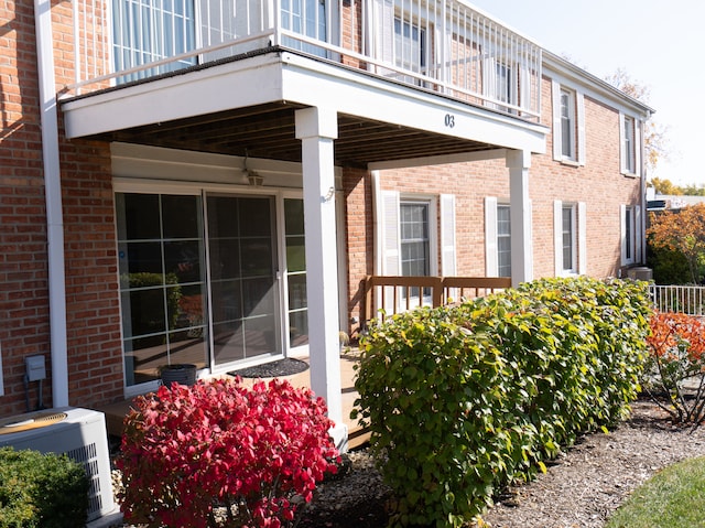 view of side of home featuring central AC unit and a balcony