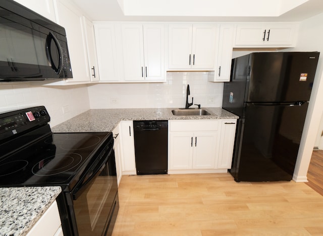 kitchen featuring white cabinets, sink, light hardwood / wood-style floors, and black appliances