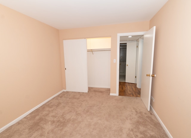 unfurnished bedroom with light carpet and a closet