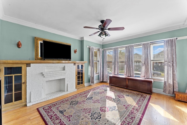 living room with ornamental molding, hardwood / wood-style flooring, radiator, and a brick fireplace