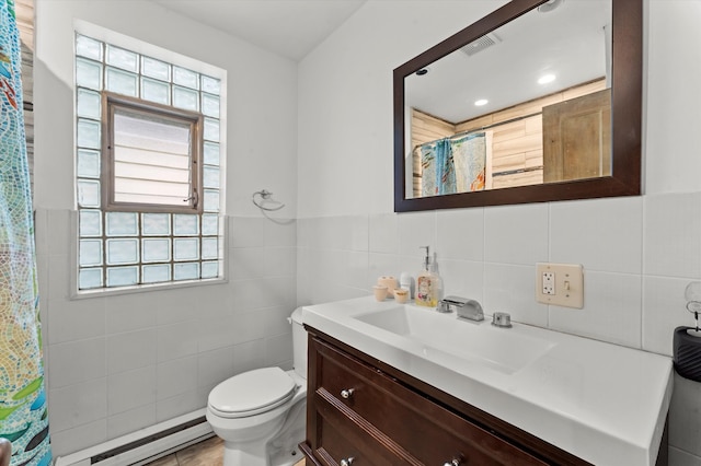 bathroom with vanity, toilet, tile walls, and baseboard heating