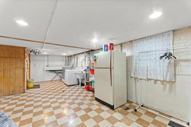 basement featuring white fridge and washer / clothes dryer