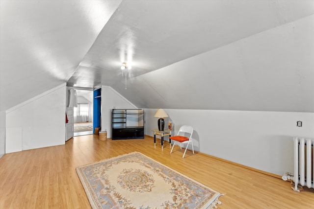 bonus room with hardwood / wood-style flooring, lofted ceiling, and radiator heating unit