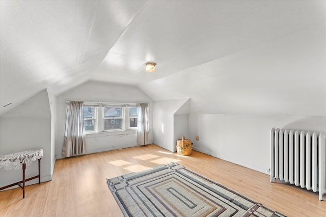 bonus room with radiator, vaulted ceiling, and light hardwood / wood-style flooring