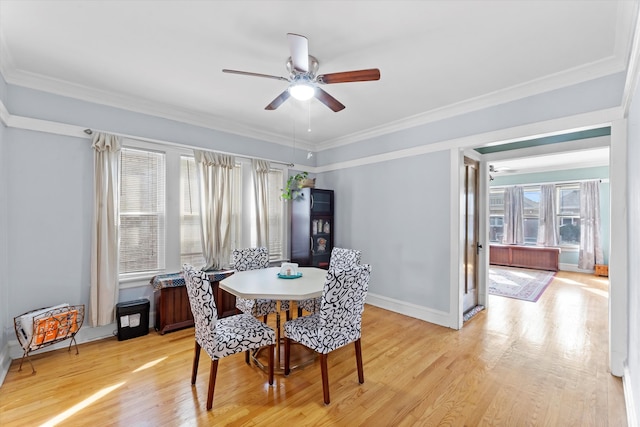 dining room with crown molding, light wood-type flooring, and ceiling fan