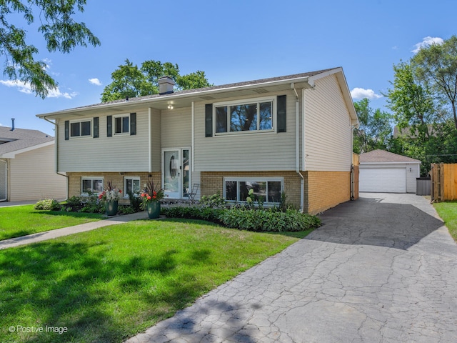 raised ranch featuring an outdoor structure, a garage, and a front lawn