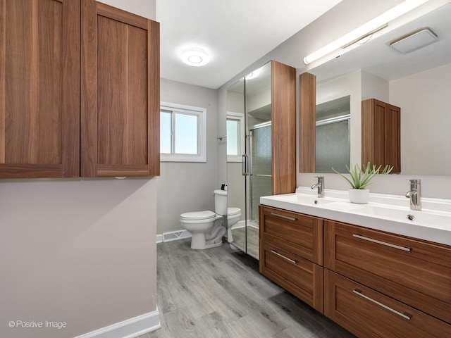 bathroom with vanity, toilet, hardwood / wood-style flooring, and walk in shower