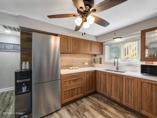 kitchen with appliances with stainless steel finishes, ceiling fan, sink, and dark hardwood / wood-style flooring