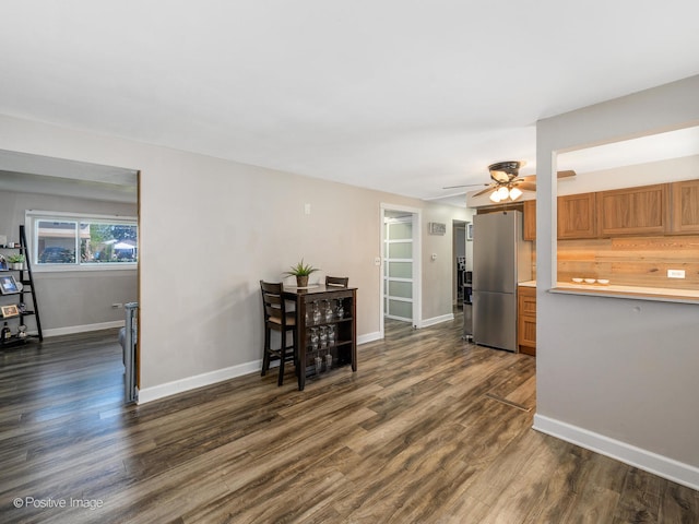 kitchen with dark hardwood / wood-style flooring, ceiling fan, and stainless steel refrigerator