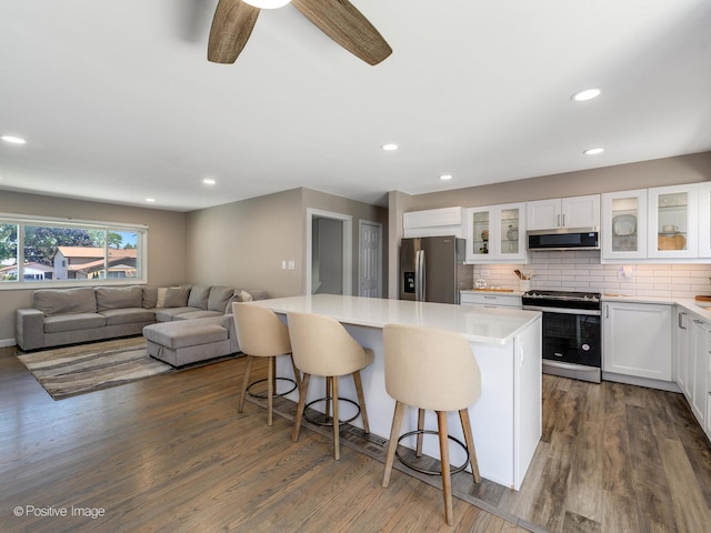 kitchen featuring a kitchen island, appliances with stainless steel finishes, dark wood-type flooring, and white cabinetry