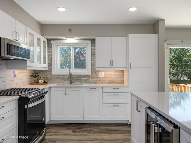 kitchen with white cabinetry, wine cooler, a healthy amount of sunlight, and appliances with stainless steel finishes