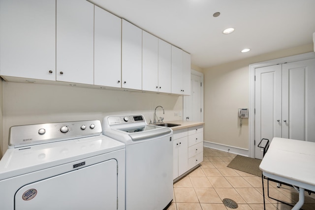 washroom featuring sink, independent washer and dryer, light tile patterned floors, and cabinets