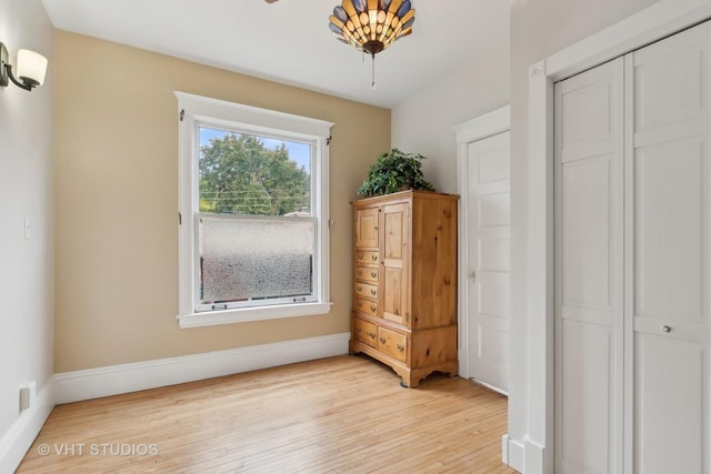 unfurnished bedroom with a closet, light wood-style flooring, and baseboards