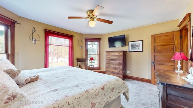 carpeted bedroom with a ceiling fan and baseboards