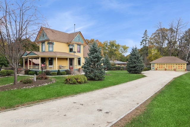 view of side of property with covered porch, a detached garage, and a lawn
