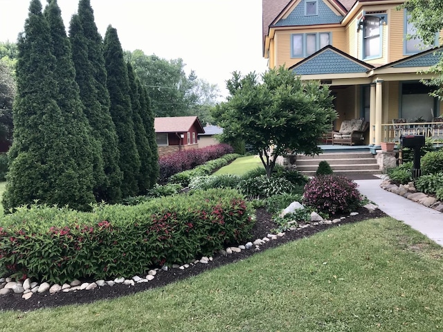 exterior space with covered porch and a front yard